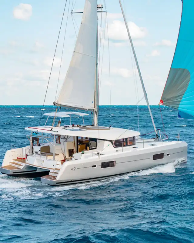 Lagoon 42 catamaran sailing in open sea with a blue spinnaker