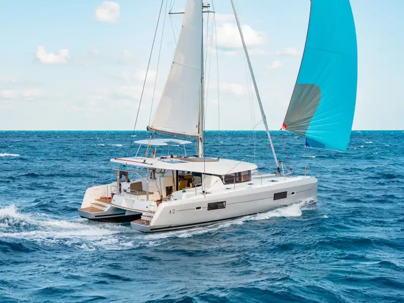 Lagoon 42 catamaran sailing in open sea with a blue spinnaker